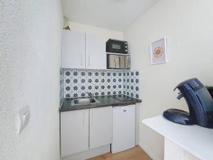 a small kitchen with a sink and a microwave at T2 avec loggia, Résidence avec piscine à Vieux-Boucau - FR-1-857-7 in Vieux-Boucau-les-Bains