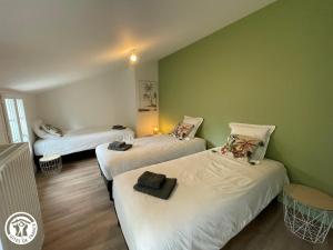 two beds in a room with green walls at Maison familiale avec babyfoot et piscine chauffée - FR-1-426-597 in Soullans +14 photos