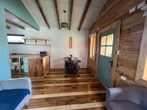 a room with wooden floors and a kitchen with a door at Cabañas - Casa Rural 32 in Villa O'Higgins