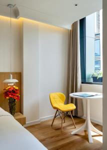 een slaapkamer met een tafel en een gele stoel bij APEC WANDER HOTEL - Near Tan Dinh Market in Ho Chi Minh-stad