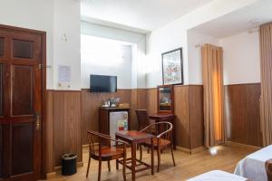 a room with a table and chairs and a tv at Minh Châu Hotel in Kon Rung (1)