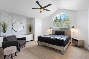 a bedroom with a bed and a chair and a window at Lake, Hot Tub, Golf Retreat in Hayden Lake