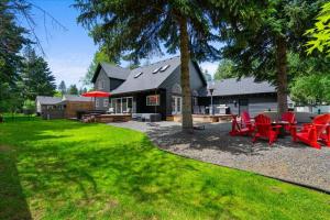 a backyard with red chairs and a house at Lake, Hot Tub, Golf Retreat in Hayden Lake