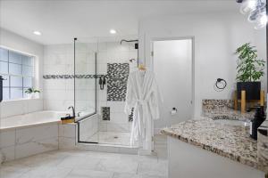 a white bathroom with a shower and a sink at Lake, Hot Tub, Golf Retreat in Hayden Lake +35 photos