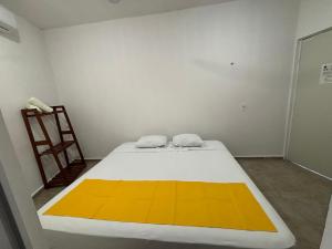 a bedroom with a large bed with a yellow blanket at Departamento AF2 in Tizimín