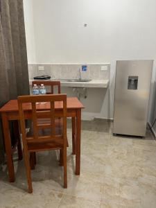 a kitchen with a table and a sink and a refrigerator at Departamento AF2 in Tizimín