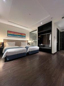 a large bedroom with two beds and a large mirror at Homestay Sapphire Studio với City View in Ha Long