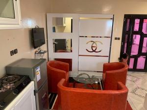 a kitchen with a glass table and orange chairs at Residence Cabral in Guediawaye