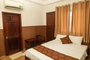 a small bedroom with a bed and a window at Minh Châu Hotel in Kon Rung (1)