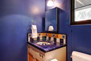 een blauwe badkamer met een wastafel en een spiegel bij West Beach Villa 5 in Santa Barbara +34 foto's