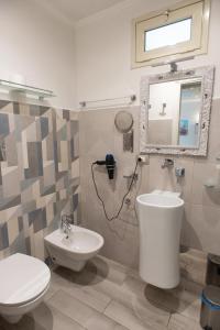 Un baño con inodoro, lavabo y espejo. en Federico 70 Smeraldo, en Palermo