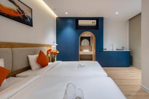 een slaapkamer met een groot wit bed en een blauwe muur bij APEC WANDER HOTEL - Near Tan Dinh Market in Ho Chi Minh-stad +57 foto's