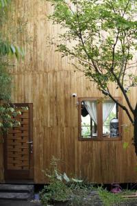 a wooden building with a door and a window at Ubuntu Bali Eco Yoga Retreat - CANGGU in Canggu