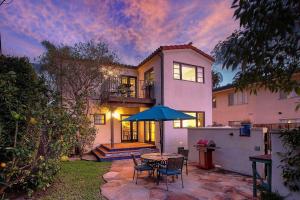 een huis met een tafel en stoelen en een paraplu bij West Beach Villa 5 & 6 in Santa Barbara