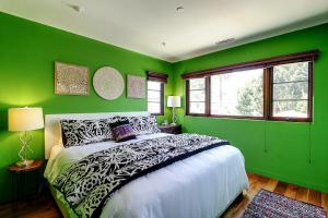 een groene slaapkamer met een groot bed. bij West Beach Villa 5 & 6 in Santa Barbara