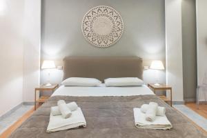 Un dormitorio con una cama grande con toallas. en Federico 70 Smeraldo, en Palermo