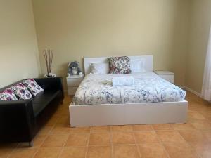a bedroom with a white bed and a black couch at Beachside Apartment in Apollo Bay