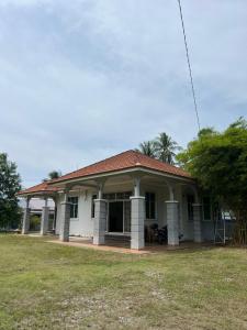 a small white house with a roof at Roomstay Bintong in Kangar