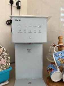 a white refrigerator with a calendar on top of it at Roomstay Bintong in Kangar