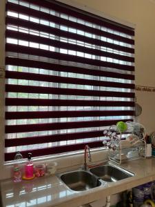 a kitchen sink in front of a window at Roomstay Bintong in Kangar