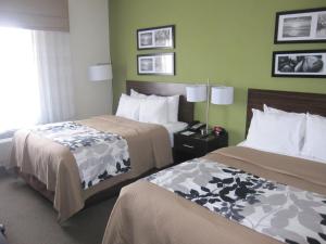 a hotel room with two beds and a window at Cresthaven Inn Jamaica-JFK in Queens