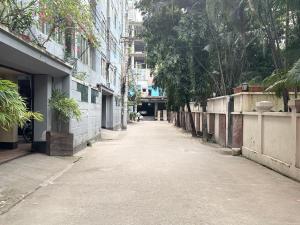 an empty street in an alley with trees and buildings at Modern Luxury Escape Balcony & Family Friendly in Dhaka