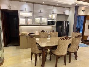 a kitchen with a dining room table and chairs at Modern Luxury Escape Balcony & Family Friendly in Dhaka