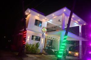 ein weißes Haus mit farbenfroher Beleuchtung davor in der Unterkunft Kokan beach cottage in Alibag