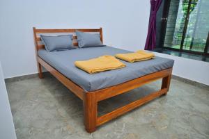 ein Bett mit zwei Kissen darauf in der Unterkunft Kokan beach cottage in Alibag