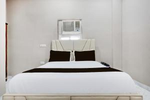 a white bed in a white room with a window at Collection O Sector 33 Gurgaon in Gurgaon
