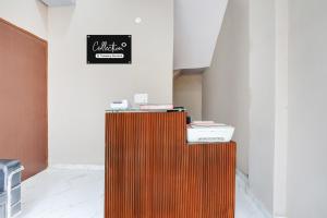 a room with a desk with a clock on the wall at Collection O Sector 33 Gurgaon in Gurgaon