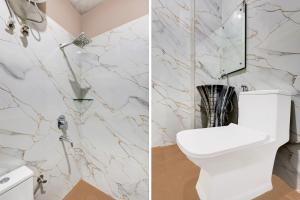 a bathroom with a white toilet and a marble wall at Collection O Sector 33 Gurgaon in Gurgaon