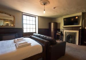 een slaapkamer met een bed, een open haard en een televisie bij Alma Inn & Dining Rooms in Harwich