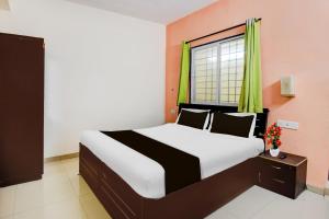 Un dormitorio con una cama grande con ventana. en Super Hotel O Hinjewadi Kirti Classic Gate, en Pune