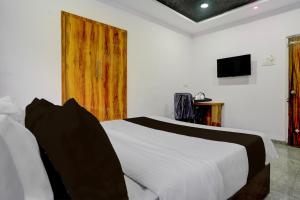 アウランガーバードにあるSuper Townhouse Chhatrapati Shivaji Maharaj Museum Formerly 7 Hillsの白いベッドと木製のドアが備わるベッドルーム1室が備わります。 +21枚の写真