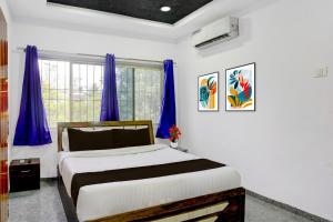 a bedroom with a large bed with purple curtains at Super Townhouse Chhatrapati Shivaji Maharaj Museum Formerly 7 Hills in Aurangabad +23 photos