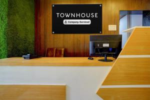 a desk with a computer and a sign on the wall at Super Townhouse Chhatrapati Shivaji Maharaj Museum Formerly 7 Hills in Aurangabad