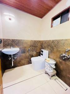 a bathroom with a toilet and a sink at Coolspot Cottage in Ooty