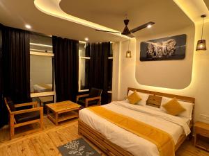 a bedroom with a bed and a ceiling fan at Varlaxmi Vatika in Rānīkhet