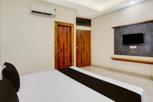 a bedroom with a bed and a flat screen tv at Super Townhouse Varanasi City Station Formerly S Kumar Inn in Varanasi