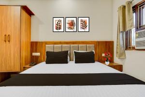 a bedroom with a large white bed with black pillows at Super Townhouse Varanasi City Station Formerly S Kumar Inn in Varanasi