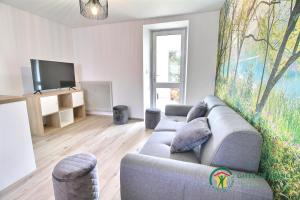 a living room with a couch and a tv at Gite de kermativan in La Trinité-Surzur
