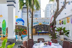 ein Restaurant mit Tischen, Stühlen und Palmen in der Unterkunft Villa Hồ Bơi Vũng Tàu Đi Bộ Ra Biển - Gần Tháp Tam Thắng - Amy 7 in Vũng Tàu