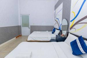 ein Zimmer mit zwei Betten und einem Gemälde an der Wand in der Unterkunft Villa Hồ Bơi Vũng Tàu Đi Bộ Ra Biển - Gần Tháp Tam Thắng - Amy 7 in Vũng Tàu