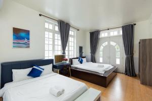 ein Hotelzimmer mit zwei Betten und einem Fenster in der Unterkunft Villa Hồ Bơi Vũng Tàu Đi Bộ Ra Biển - Gần Tháp Tam Thắng - Amy 7 in Vũng Tàu + 2 Fotos