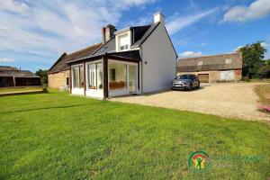 a house with a car parked in the driveway at Gite de kermativan in La Trinité-Surzur