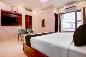 a bedroom with a large bed and a tv at Super Townhouse Naya Gaon Formerly Hotel Paradise in Chandīgarh