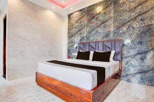 チャンディーガルにあるSuper Townhouse Naya Gaon Formerly Hotel Paradiseの大理石の壁のベッドルーム1室(ベッド1台付)