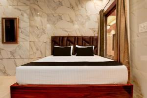 チャンディーガルにあるSuper Townhouse Naya Gaon Formerly Hotel Paradiseの大理石の壁のベッドルーム1室