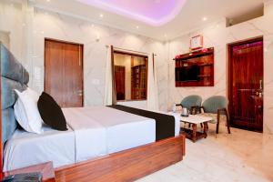 チャンディーガルにあるSuper Townhouse Naya Gaon Formerly Hotel Paradiseのベッドとテーブルと椅子のある寝室 +24枚の写真